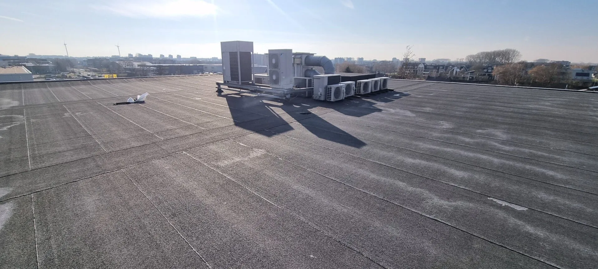 Grootschalig plat dak met installaties op een bedrijfspand