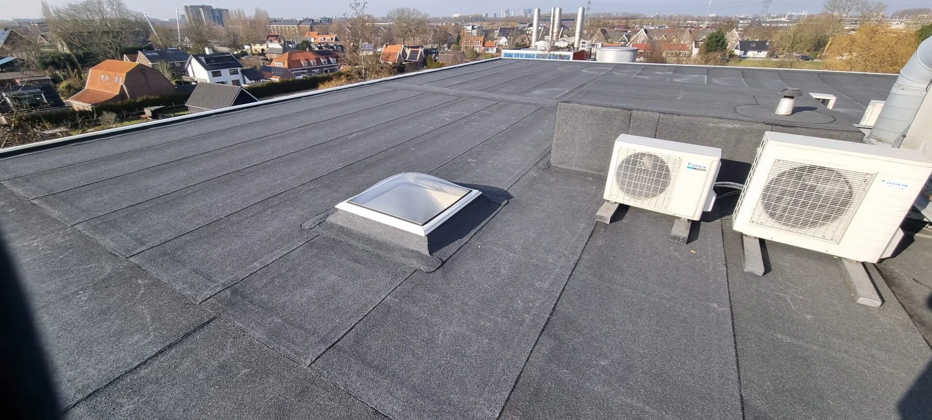 Plat dak met lichtkoepel en uitzicht over de stad