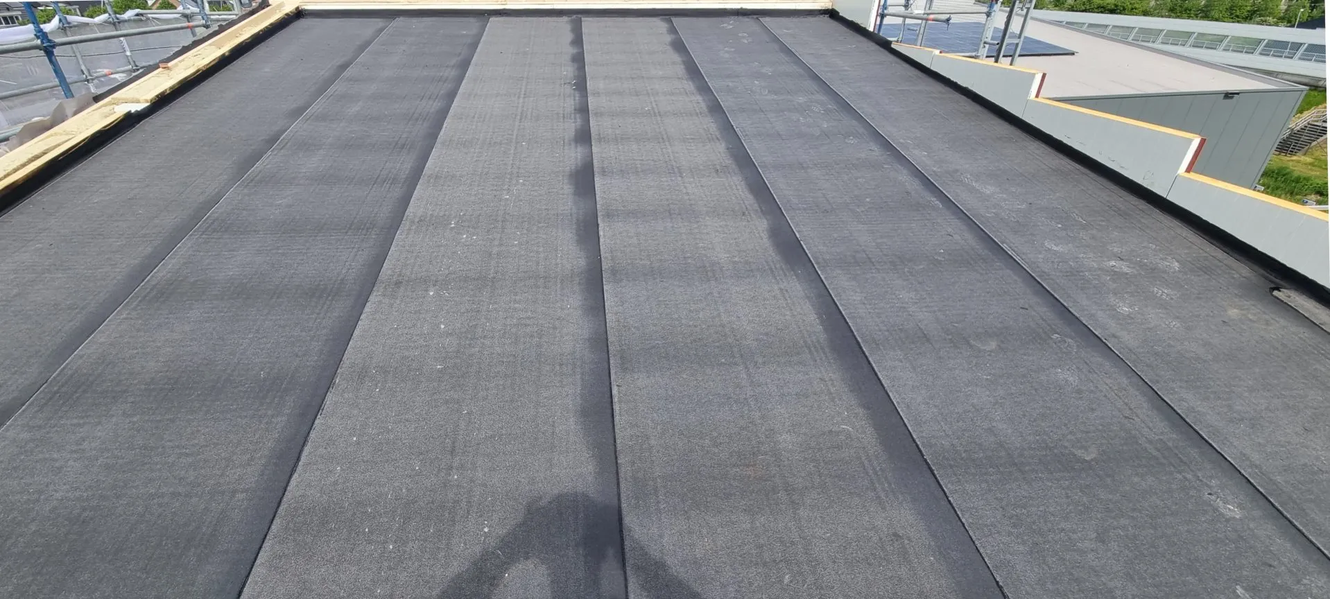 Ruim plat dak onder een open lucht, strak in het bitumen